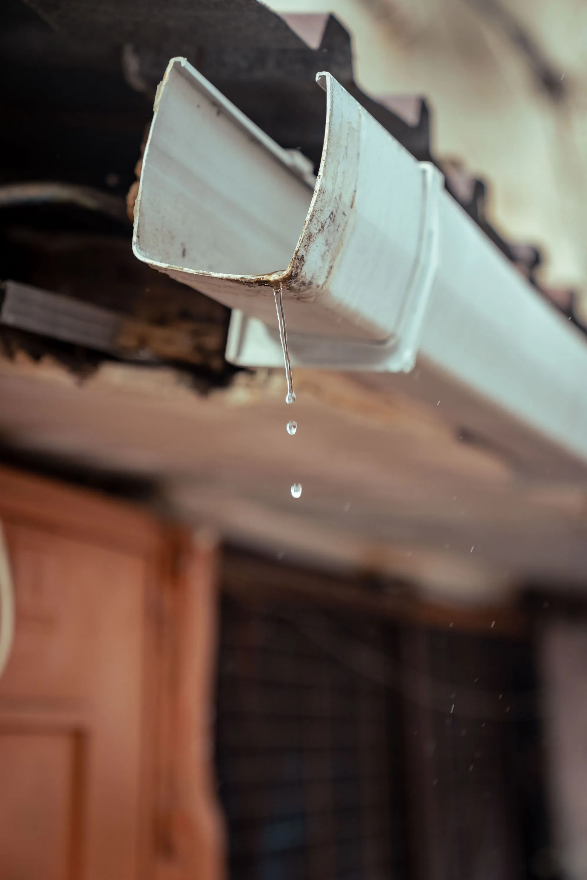 Rainwater running off the lip of a house gutter