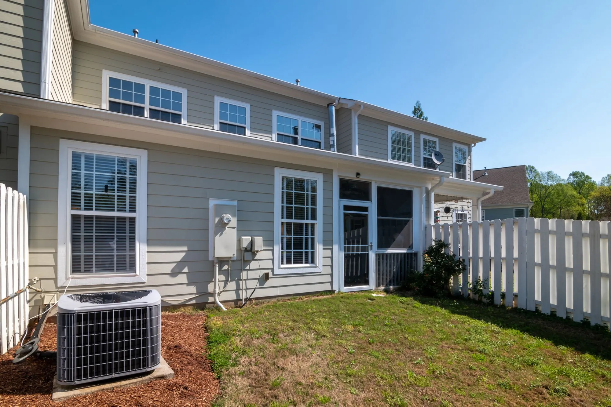 The sided rear elevation of a suburban house with its gutter line above