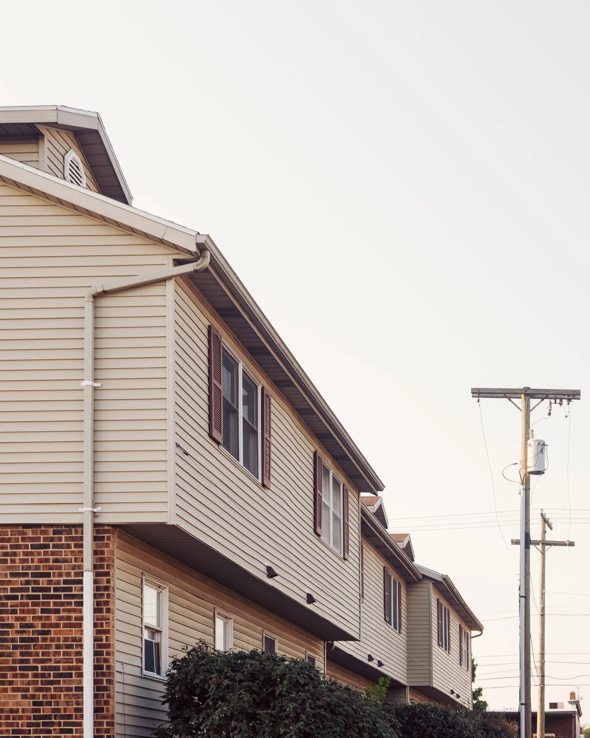 A row of two-storey suburban homes with sided walls and shingled roofs